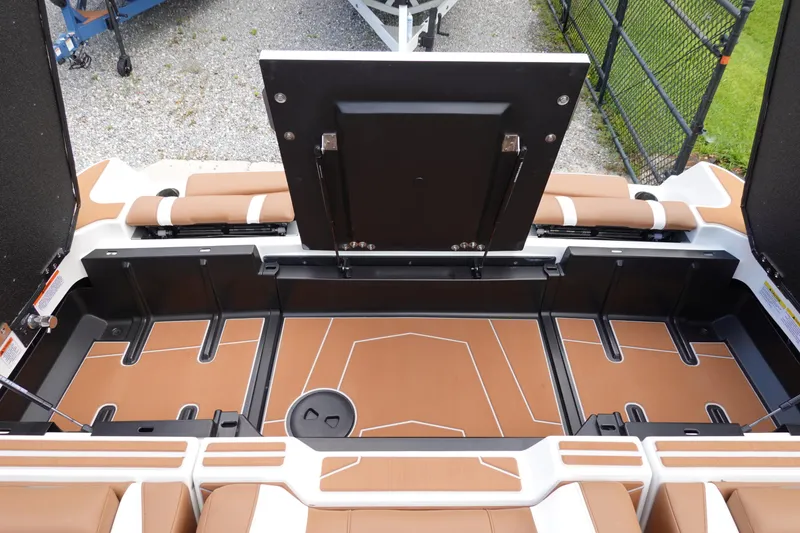 Slide: The Image of 2025 Malibu Wakesetter 25 LSV boat storage compartment with brown and white interior. - 47