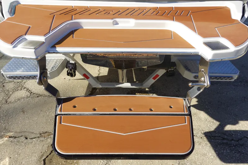 Slide: The Image of 2025 Malibu Wakesetter 25 LSV swim platform with teak finish and metal accents. - 9