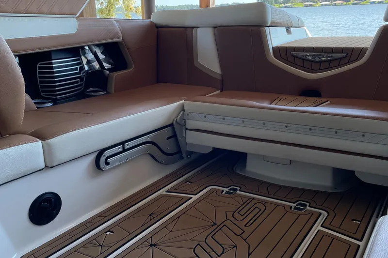 Slide: The Image of 2019 Nautique Super Air Nautique G23 Coastal Edition interior with brown and white seating. - 4