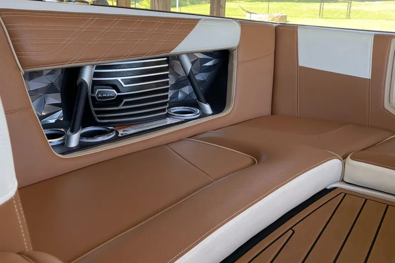Slide: The Image of 2019 Nautique Super Air Nautique G23 Coastal Edition interior with brown leather seating and speaker system. - 9