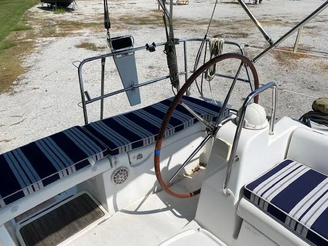 Slide: The Image of 2009 Beneteau Oceanis 40 sailboat cockpit with striped cushions and wooden steering wheel. - 11