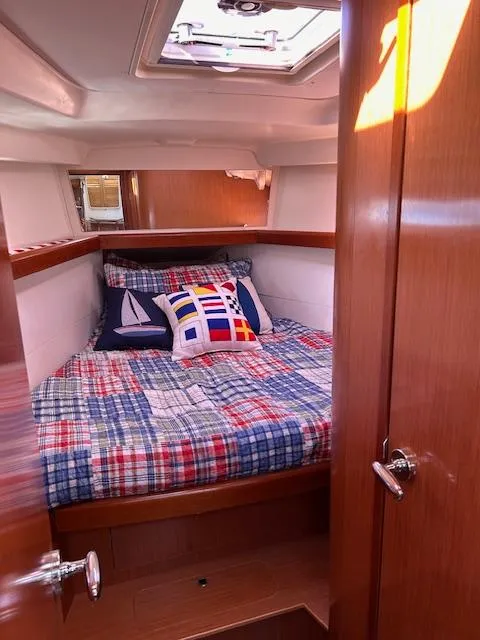 Slide: The Image of Cozy cabin interior of 2009 Beneteau Oceanis 40 sailboat with nautical-themed bedding. - 16