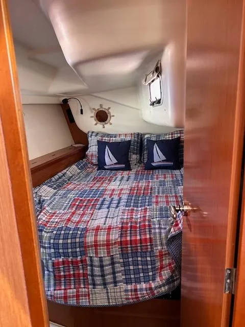 Slide: The Image of Cozy cabin interior of 2009 Beneteau Oceanis 40 sailboat with nautical-themed bedding. - 17