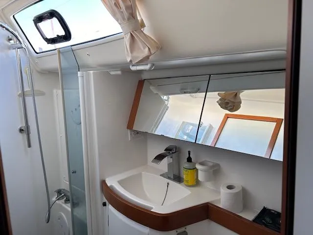Slide: The Image of Beneteau Oceanis 40 bathroom interior, featuring a modern sink and mirrored cabinets, 2009 model. - 18