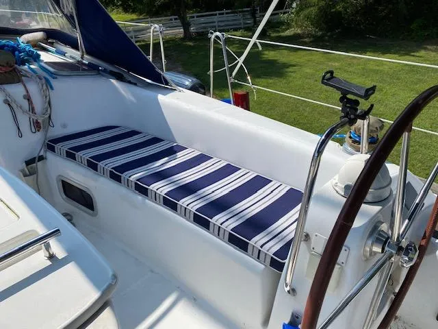 Slide: The Image of Beneteau Oceanis 40 cockpit with striped cushion, 2009 model, featuring steering wheel and outdoor setting. - 9