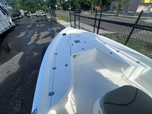 Slide: The Image of 2019 NauticStar 2140 Sport boat, white deck, parked near a fence. - 10