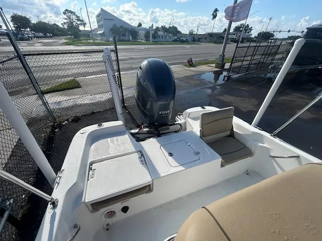 Slide: The Image of 2019 NauticStar 2140 Sport boat with Yamaha 150 engine, parked near a fence. - 15