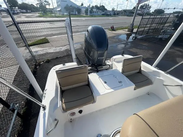 Slide: The Image of 2019 NauticStar 2140 Sport boat with Yamaha outboard motor, docked near a fence. - 16