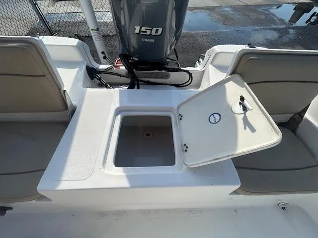 Slide: The Image of 2019 NauticStar 2140 Sport boat with open storage compartment and Yamaha 150 engine. - 17