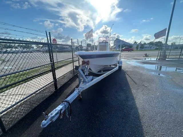 Slide: The Image of 2019 NauticStar 2140 Sport boat on trailer, parked near a fence under a bright sky. - 4