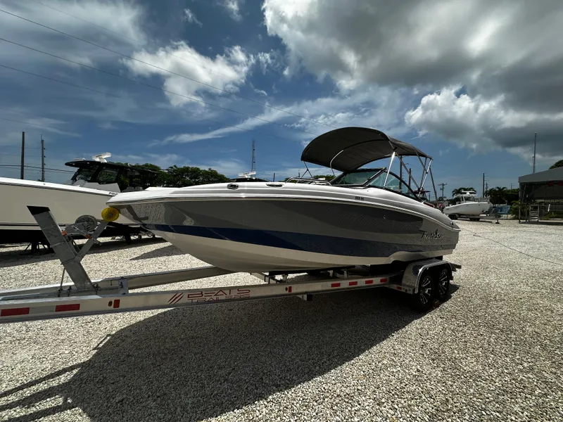 Slide: The Image of 2024 NauticStar 203 DC boat on trailer under cloudy sky. - 1
