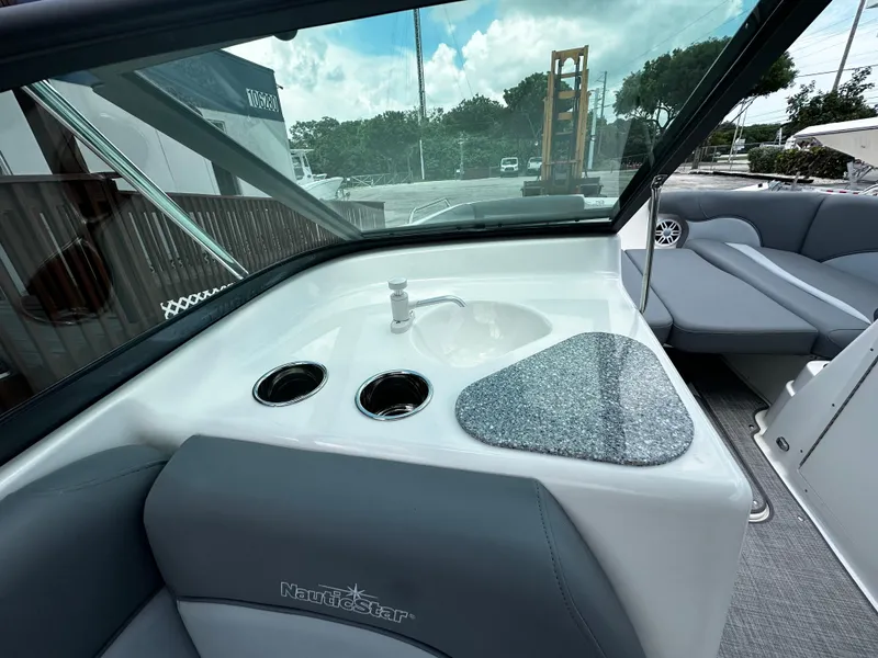 Slide: The Image of 2024 NauticStar 203 DC boat interior with sink and seating area. - 18
