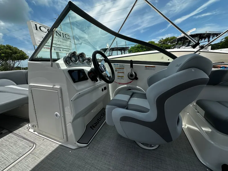 Slide: The Image of 2024 NauticStar 203 DC boat interior with steering wheel and seating. - 9