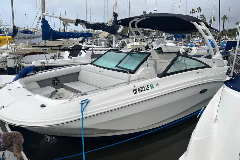 The Image of 2021 Sea Ray SDX 250 Outboard boat docked in marina, featuring sleek design and spacious seating. - 0