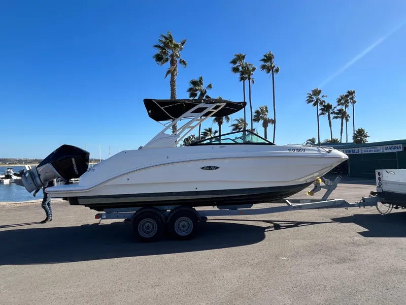 Slide: The Image of 2021 Sea Ray SDX 250 Outboard boat on trailer, parked near palm trees. - 5