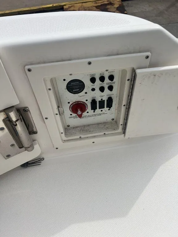 Slide: The Image of Control panel on a 2023 Robalo R242 boat, featuring switches and a red dial. - 10