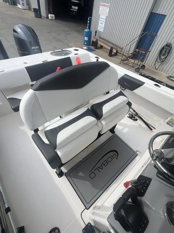 Slide: The Image of 2023 Robalo R242 boat interior with dual seating and steering console. - 16