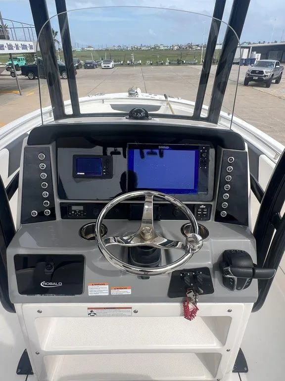 Slide: The Image of 2023 Robalo R242 boat dashboard with steering wheel and navigation screens. - 17