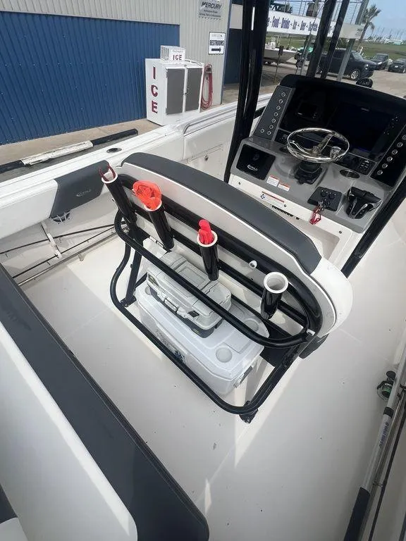 Slide: The Image of 2023 Robalo R242 boat interior with helm, rod holders, and cooler. - 18