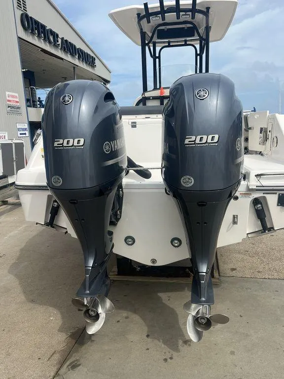 Slide: The Image of 2023 Robalo R242 boat with twin Yamaha 200 engines at a marina. - 2