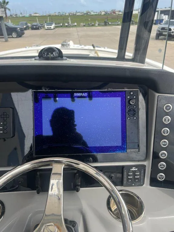 Slide: The Image of 2023 Robalo R242 boat dashboard with Simrad display and steering wheel. - 21