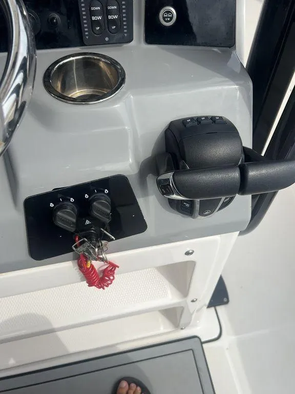 Slide: The Image of 2023 Robalo R242 boat control panel with throttle and ignition keys. - 23