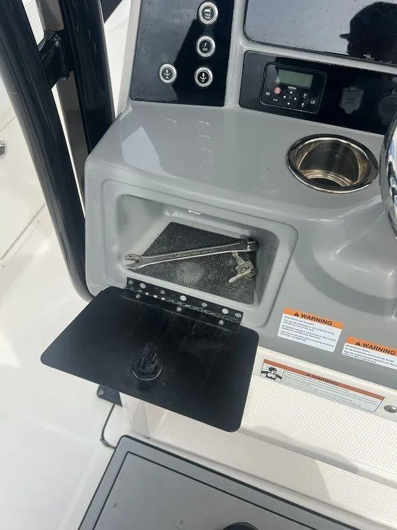 Slide: The Image of 2023 Robalo R242 boat console with storage compartment and cup holder. - 24