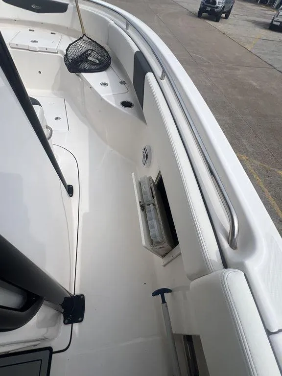 Slide: The Image of 2023 Robalo R242 boat interior with fishing net and storage compartments. - 26