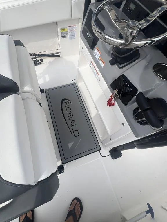 Slide: The Image of 2023 Robalo R242 boat interior with steering wheel and seating. - 27