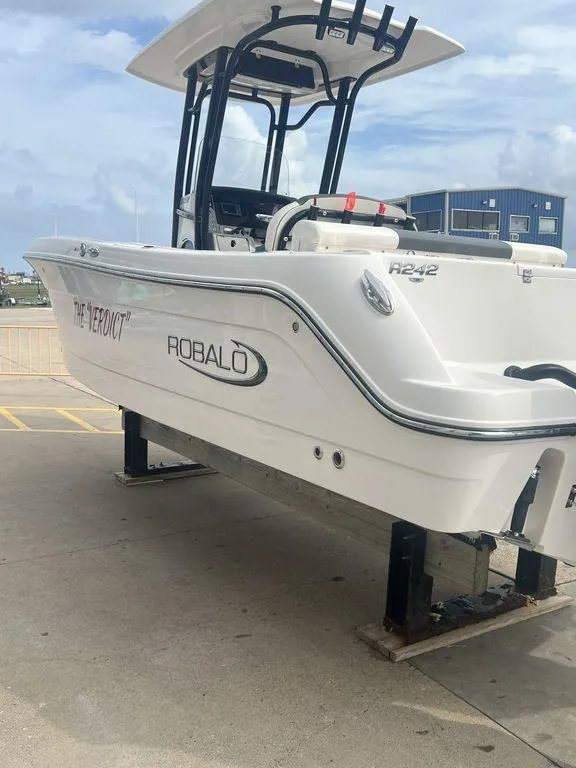 Slide: The Image of 2023 Robalo R242 boat on display at a marina. - 3