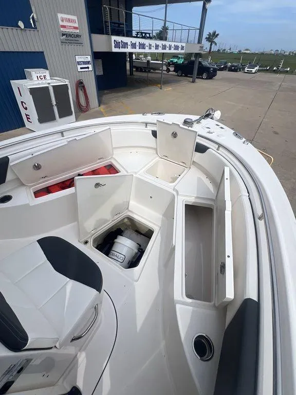 Slide: The Image of 2023 Robalo R242 boat with open storage compartments at a marina. - 32