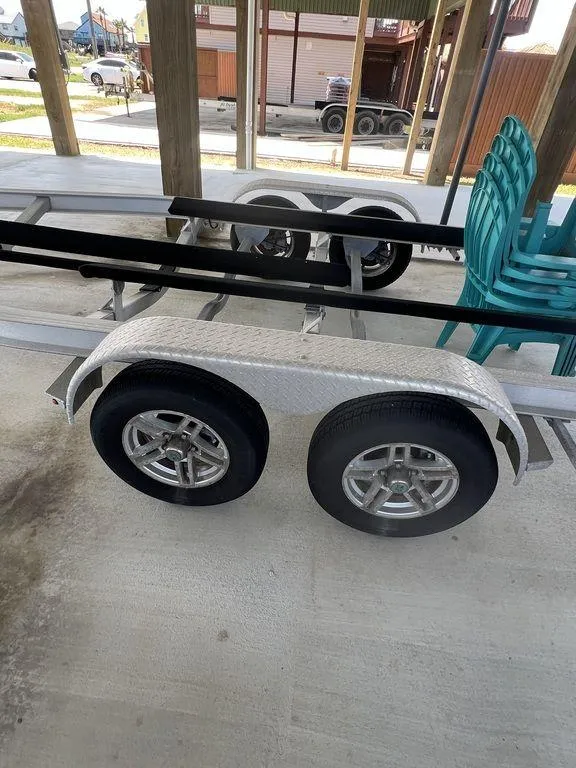 Slide: The Image of 2023 Robalo R242 boat trailer with dual wheels parked under a shelter. - 39