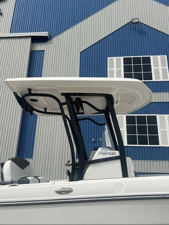 Slide: The Image of 2023 Robalo R242 boat with T-top against blue building background. - 4