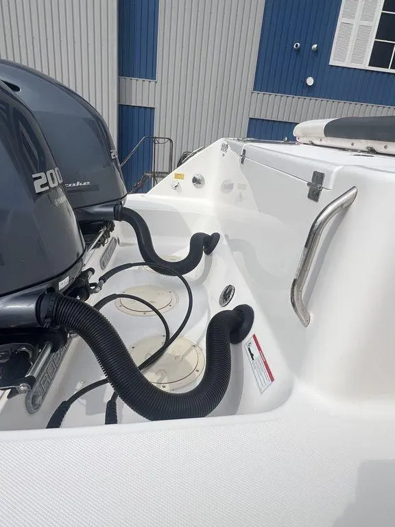 Slide: The Image of 2023 Robalo R242 boat engine area with dual motors and hoses. - 6