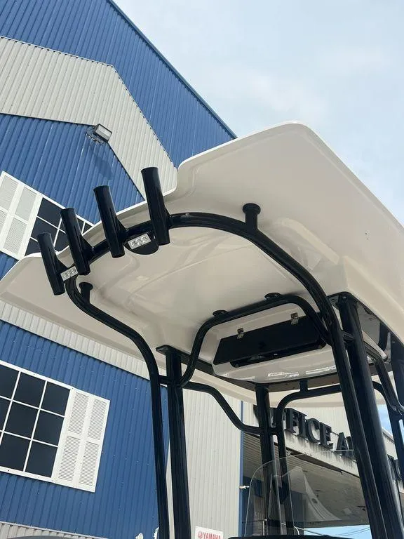 Slide: The Image of 2023 Robalo R242 boat T-top against industrial building background. - 8