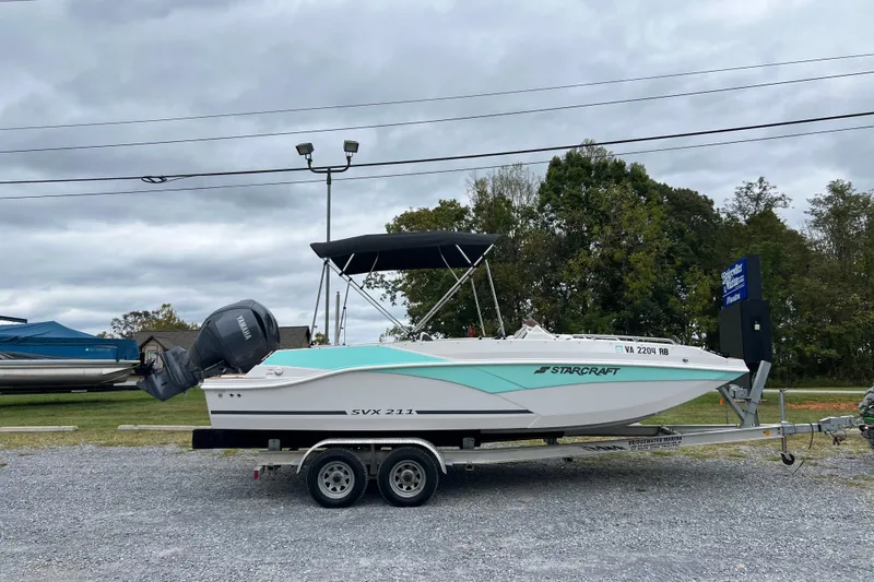 Slide: The Image of 2024 Starcraft SVX 211 OB boat on trailer, featuring Yamaha outboard motor. - 12