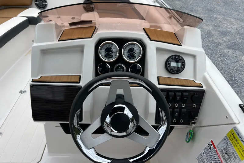 Slide: The Image of 2024 Starcraft SVX 211 OB boat dashboard with steering wheel and control panel. - 15
