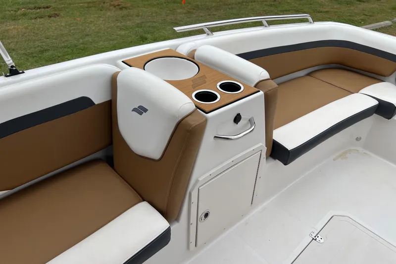 Slide: The Image of 2024 Starcraft SVX 211 OB boat interior with tan and white seating, cup holders, and storage. - 19