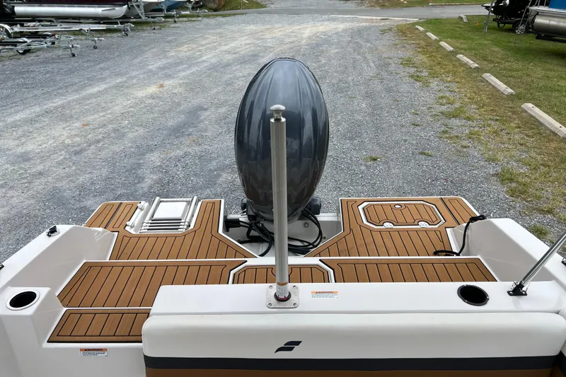 Slide: The Image of 2024 Starcraft SVX 211 OB boat with teak-style deck, outboard motor, and ladder. - 21