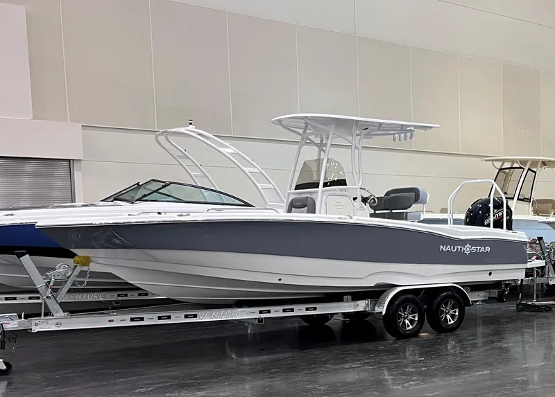 The Image of 2025 NauticStar 231 Hybrid boat on trailer in showroom. - 0