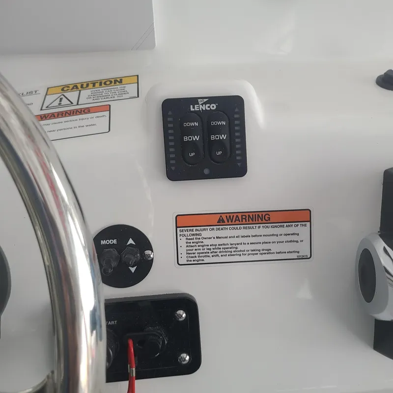 Slide: The Image of 2025 NauticStar 231 Hybrid boat dashboard with Lenco controls and warning labels. - 16