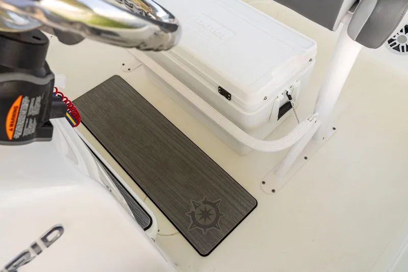 Slide: The Image of 2025 NauticStar 231 Hybrid boat interior with steering wheel and cooler. - 27