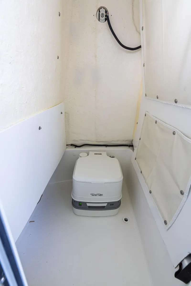 Slide: The Image of 2025 NauticStar 231 Hybrid boat interior with portable toilet. - 37