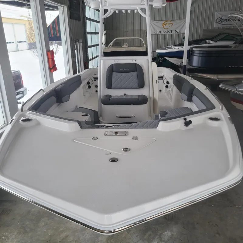 Slide: The Image of 2025 NauticStar 231 Hybrid boat in showroom, featuring sleek design and comfortable seating. - 8