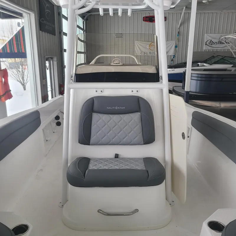 Slide: The Image of 2025 NauticStar 231 Hybrid boat interior with gray seating in showroom. - 9