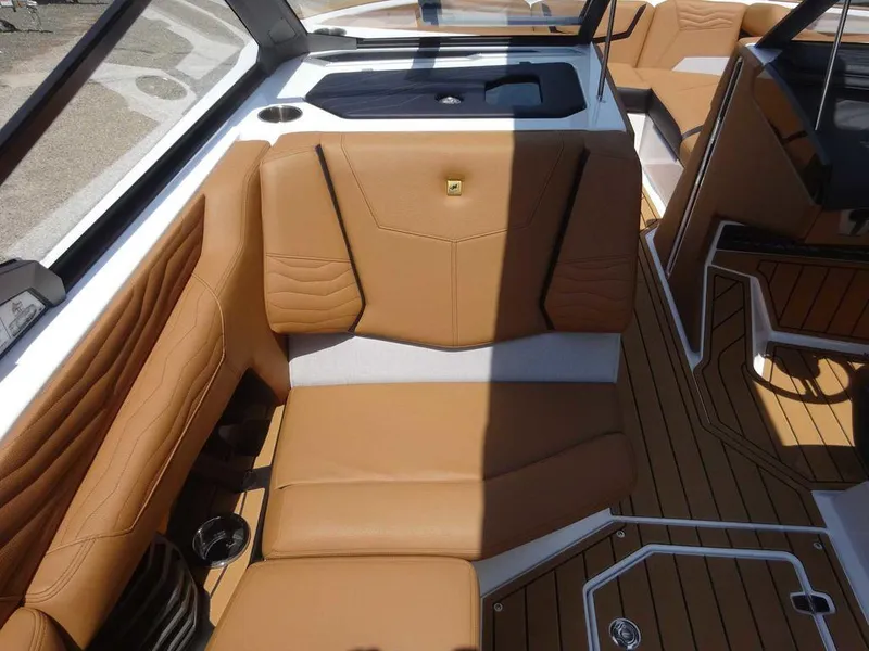 Slide: The Image of 2025 Nautique G23 boat interior with tan leather seating and modern design. - 13