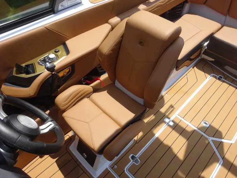 Slide: The Image of 2025 Nautique G23 boat interior with tan leather seating and modern controls. - 3
