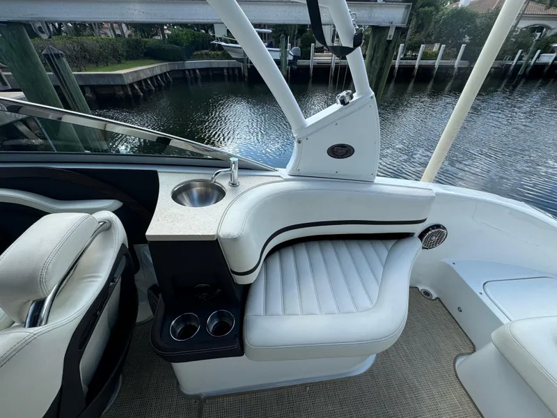 Slide: The Image of 2015 Cobalt R7 boat interior with white seating and cup holders by the water. - 13