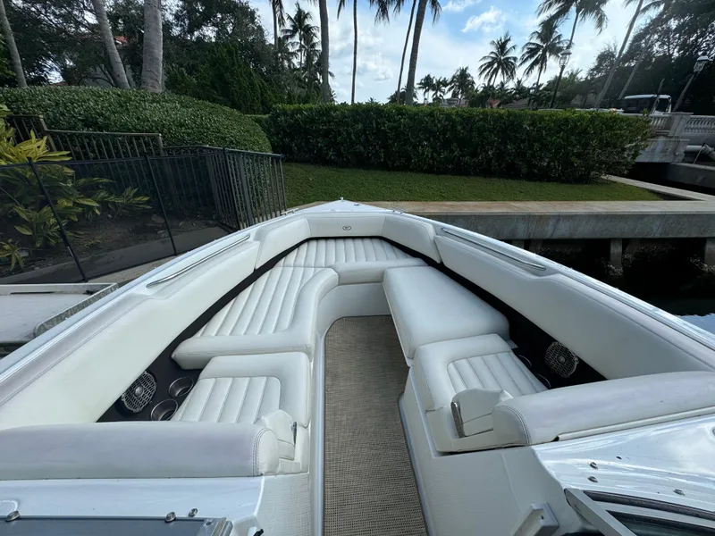 Slide: The Image of 2015 Cobalt R7 boat with white seating, docked near lush greenery and palm trees. - 15