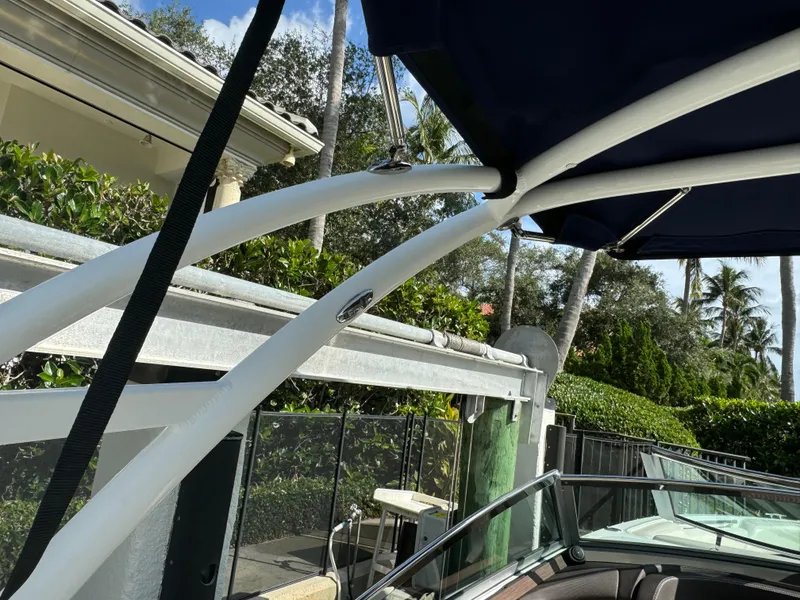 Slide: The Image of 2015 Cobalt R7 boat with canopy, docked near lush greenery and residential area. - 21